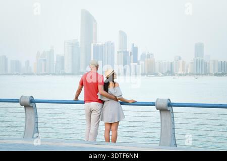 Kaukasische Touristen romantische Paare stehen zusammen und genießen das Panorama der Skyline auf dem malerischen Aussichtspunkt in Abu dhabi. Besuchen Sie die Reise Sightseeing VAE Concept Stockfoto