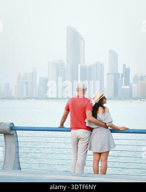 Kaukasische Touristen romantische Paare stehen zusammen und genießen das Panorama der Skyline auf dem malerischen Aussichtspunkt in Abu dhabi. Besuchen Sie die Reise Sightseeing VAE Concept Stockfoto