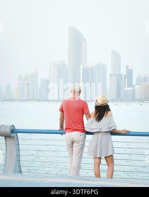 Kaukasische Touristen romantische Paare stehen zusammen und genießen das Panorama der Skyline auf dem malerischen Aussichtspunkt in Abu dhabi. Besuchen Sie die Reise Sightseeing VAE Concept Stockfoto