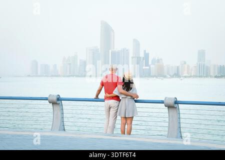 Kaukasische Touristen romantische Paare stehen zusammen und genießen das Panorama der Skyline auf dem malerischen Aussichtspunkt in Abu dhabi. Besuchen Sie die Reise Sightseeing VAE Concept Stockfoto