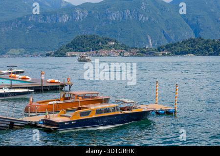 Luxuriöse Motorboote aus Holz, die am Pier am Scenic Mountain Lake vor Anker liegen Stockfoto