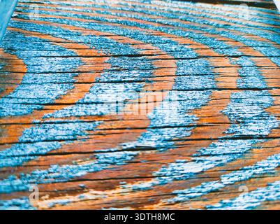 Detailgetreue Makroaufnahme aus gereiftem Holz mit leuchtender abblätternder blaublauer Farbe und tieforangefarbener Körnung. Perfekt für hochwertige Hintergründe, rustikale Texturen, an Stockfoto