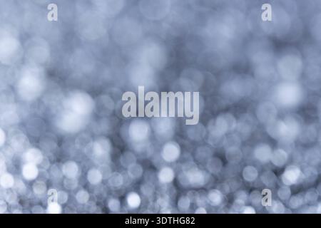 Abstrakter silberner Wassertropfen Bokeh mit funkelnden Makrotropfen. Eine hochwertige Makroaufnahme von sprudelnden Wassertröpfchen Stockfoto