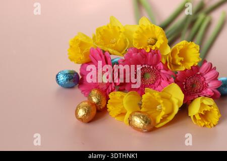 Bouquet von Narzissen und Gerberas auf rosa Hintergrund Stockfoto