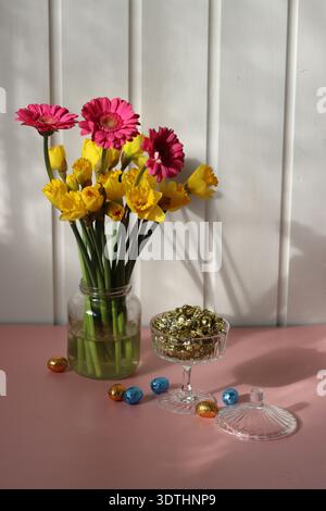 Bouquet von Narzissen und Gerberas auf rosa Hintergrund Stockfoto