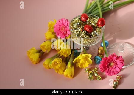 Bouquet von Narzissen und Gerberas auf rosa Hintergrund Stockfoto