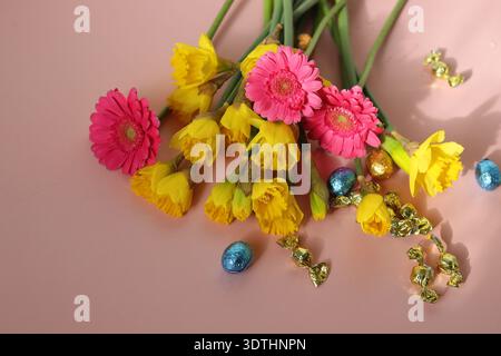Bouquet von Narzissen und Gerberas auf rosa Hintergrund Stockfoto