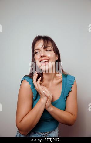 Fröhliche junge Frau posiert spielerisch isoliert auf hellem Studio Hintergrund. Stockfoto