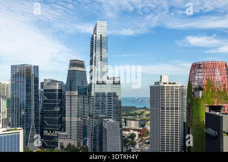 Moderne Glashochhäuser des Finanzviertels Marina Bay mit Meer und verankerten Schiffen im Hintergrund, Singapur Stockfoto