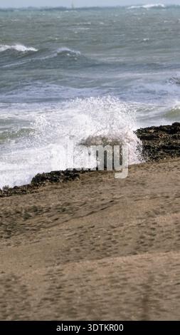 Vertikale Aufnahme: Küstenwellen, die im Blowing Rocks Preserve in Florida gegen Kalkstein stürzen Stockfoto