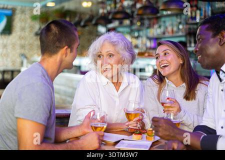 Glückliche Freunde, die Bier trinken und sich im Restaurant unterhalten Stockfoto