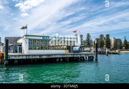 Blick auf den Fährhafen Manly Wharf vom Wasser aus, während sich eine Fähre dem Dock in Manly Cove, Sydney, nähert. Stockfoto
