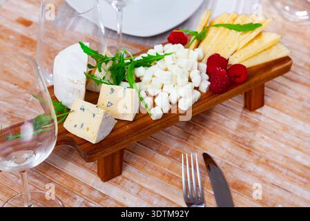 Verschiedene Käsesorten, serviert mit Himbeeren und Rucola Stockfoto