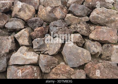 Felswand aus großen, warmen Felsblöcken. Hintergrundstruktur. Stockfoto