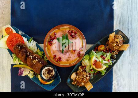 Gerichte der nahöstlichen Küche, wahrscheinlich libanesische oder arabische Gerichte auf einem blauen Tisch Stockfoto