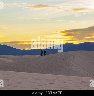 Sihouetts von Paaren wandern durch die Gipssanddünen, White Sand National Park, New Mexico, USA Stockfoto