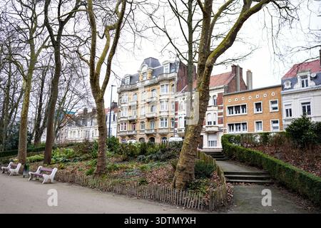 Europäischer Stadtpark mit Bänken und historischen Apartmenthäusern Stockfoto