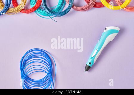 Farbenfroher 3D-Druckstift und leuchtende Filamentspulen auf violettem Hintergrund. Perfekt für kreative Hobbys, MINT-Ausbildung und Designprojekte Stockfoto
