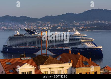 Das berühmte Apex-Kreuzfahrtschiff wird bei Sonnenaufgang über den Dächern von Vigo, hinter der Halbinsel Cangas und Morrazo gesehen. Galicien, Spanien; 29. Juli 2024 Stockfoto