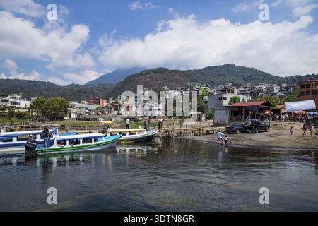 Santiago Atitlan, Guatemala - 20. März 2018: Sonniger Steg an der Küste des Atitlan-Sees mit Blick auf farbenfrohe Häuser in Santiago Atitlan, Guatemala Stockfoto