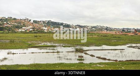 Antananarivo, Madagaskar - 24. April 2019: Typische Landschaft während des bewölkten Tages in der Nähe von Madagaskar Hauptstadt, Häuser auf kleinen Hügeln Hintergrund, Bau Stockfoto