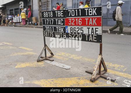 Antananarivo, Madagaskar - 24. April 2019: Autokennzeichen in der Nähe der Straße (in der Autowerkstatt), verschwommene Menschen im Hintergrund, Antanan Stockfoto