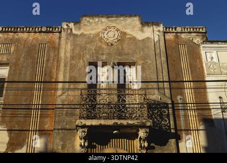 Verlassene Fassade des Kolonialhauses mit Stuck und Balkon von Sonne, Merida, Yucatan, Mexiko erhellt Stockfoto