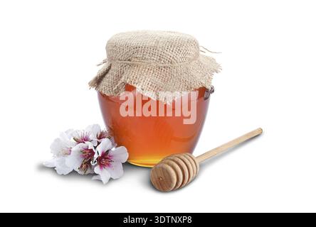Honig mit Holz Stick und Blumen isoliert auf weißem Hintergrund Stockfoto