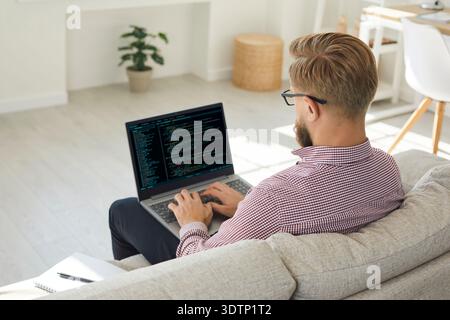 Mann codiert auf Laptop im Home Office, Remote-Software-Entwickler arbeitet online Stockfoto