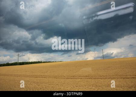 Sturmwolken über dem Erntefeld vom Zugfenster aus gesehen, ländliche Landschaft, Deutschland, nahendes Sommergewitter Stockfoto
