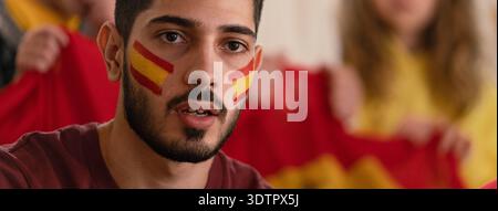 Begeisterte Fußballfans unterstützen die spanische Nationalmannschaft beim Live-Fußballspiel im Stadion. Begeisterte Fußballfans unterstützen eine spanische Nationalmannschaft in Li Stockfoto