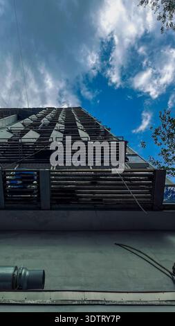Architektonisches Wunder: Ein beeindruckender Blick auf ein modernes Gebäude vor einem lebendigen Himmel mit dynamischen Wolkenmustern Stockfoto