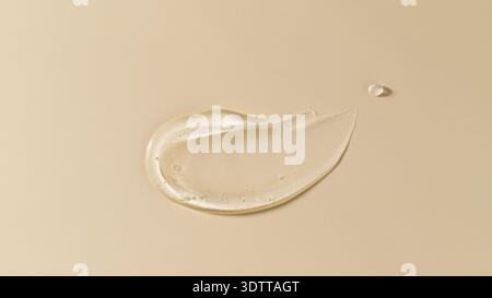 Kosmetisch-transparentes Gel-Serummuster mit Blasen isoliert auf beigem Hintergrund. Texturfeuchtigkeitsspendendes Gel der Hyaluronsäure-Nahaufnahme. Gesicht oder Körper nat Stockfoto