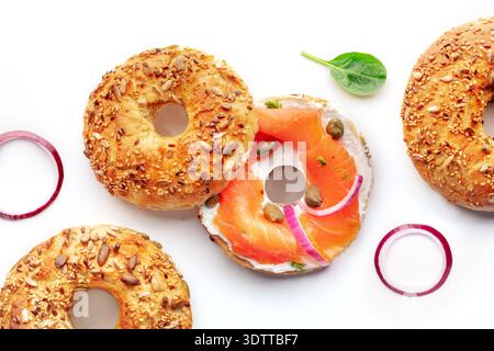 Bagels mit Lochs, Räucherlachs, Flachbild-Schuss über dem Kopf auf weißem Hintergrund, mit Zwiebeln, Kapern und Dill Stockfoto