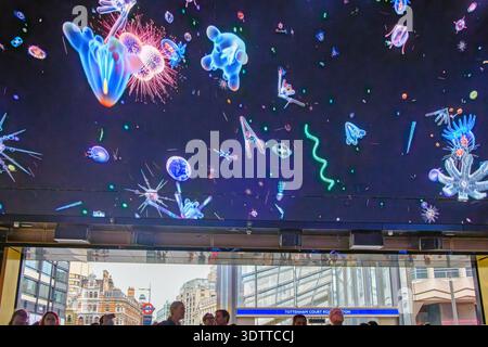 Besucher treffen sich unter der digitalen Decke im Outernet London neben der Tottenham Court Road Station im Zentrum Londons. Stockfoto