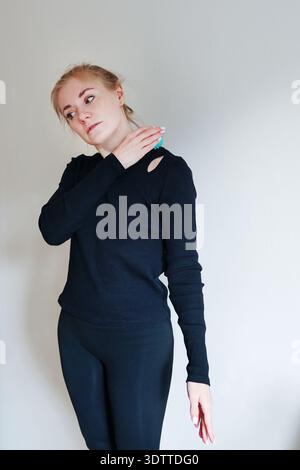 Frau mit Massageball auf der Schulter zur Muskelentlastung. Home Recovery und Self Care Konzept mit Kopierraum. Stockfoto
