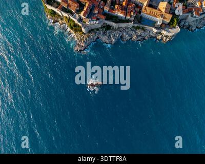 Aus der Vogelperspektive der antiken Terrakotta-Dächer treffen auf die türkisfarbene Adria, Dubrovnik, Gespanschaft Dubrovnik-Neretva, Kroatien. Stockfoto