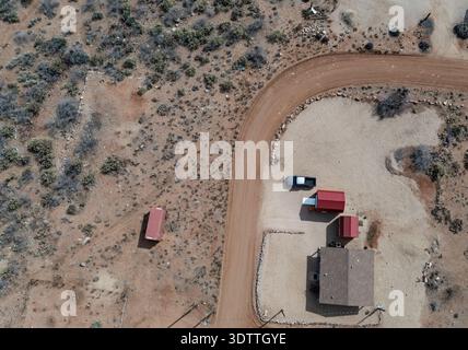 Blick aus der Vogelperspektive auf ein einsames Haus mit roten Nebengebäuden in der Nähe einer gewundenen Feldstraße, Hopewell Township, New Jersey, USA. Stockfoto