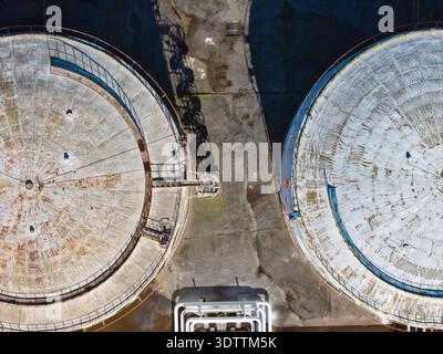 Aus der Vogelperspektive der Industrielandschaft, wo die Betontanks auf die verwitterte Erde treffen und einen starken Kontrast von Texturen und Tönen schaffen, Kalochori, Stockfoto