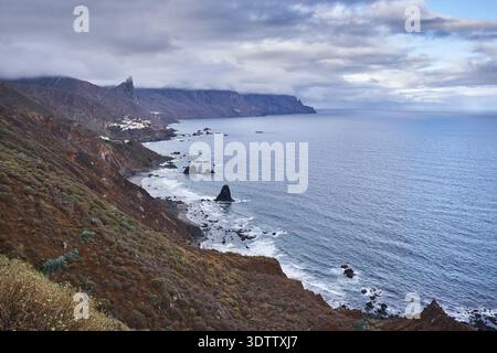 Breiter erhöhter Blick auf die Küste von Anaga mit Playa de Benijo, dem Dorf Almáciga und vulkanischen Gesteinssteinen entlang der zerklüfteten Nordküste von Stockfoto