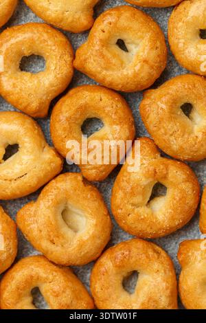 Tarallini-traditionelle italienische kleine Bagels. Taralli. Köstlicher Snack aus nächster Nähe. Kulinarischer Hintergrund. Selektiver Fokus, Draufsicht Stockfoto