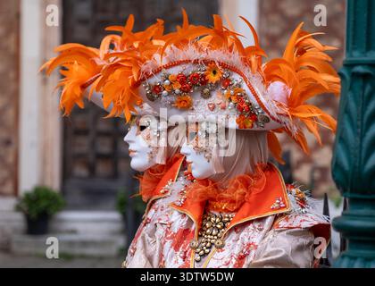 Fotogenes Paar in aufwendigen handgefertigten Kostümen posiert für die Kamera vor der Kirche San Zaccaria während des jährlichen Karnevals in Venedig, Italien. Stockfoto