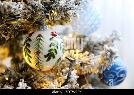 Schneebedeckter Weihnachtsbaum mit Weihnachtskugeln und Licht. Weihnachten und Feiertage. Stockfoto