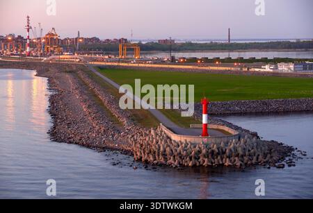 Ein erhöhter Blick auf den Hafen von Kronstadt in der Abenddämmerung mit einem markanten rot-weiß gestreiften Leuchtturm auf einem Betonpfeiler Stockfoto