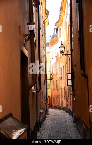 Ein Blick auf eine sehr enge Kopfsteinpflasterallee in Gamla Stan, der Altstadt von Stockholm, Schweden. Die historischen Gebäude auf beiden Seiten sind bemalt Stockfoto
