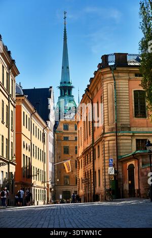 Ein bezaubernder Blick auf die Straße in Gamla Stan (Altstadt), Stockholm, Schweden, mit farbenfrohen historischen Gebäuden entlang einer schmalen Kopfsteinpflasterstraße. Das Symbol Stockfoto