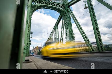Das gelbe Taxi fährt schnell an Einer Retro-Brücke in der rauschenden Stadt vorbei Stockfoto