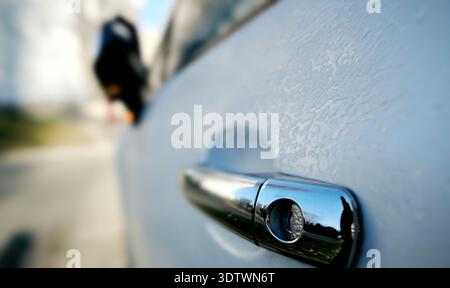 Fahrer-Türgriff eines frostbedeckten Fahrzeugs auf Parken im Morgenlicht Stockfoto