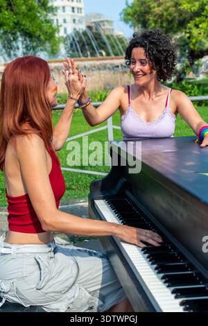 Verschiedene Frauen spielen Klavier und haben Spaß im Freien Stockfoto