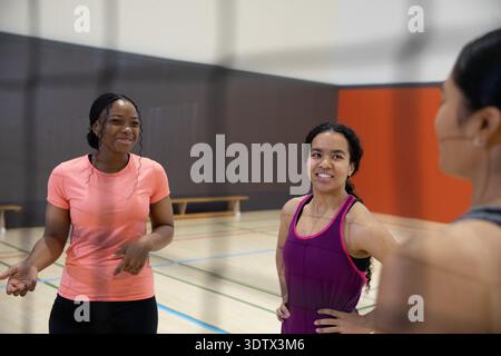 Verschiedene Freundinnen stehen und unterhalten sich auf dem Fitnessplatz mit gemalten Linien und tragen Sportbekleidung Stockfoto